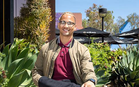 Austin Metoyer sitting outside College of Business building