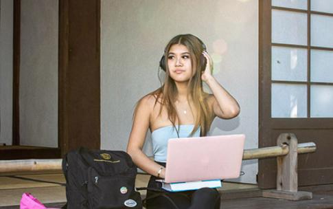 Student works on pink computer in Japanese Garden