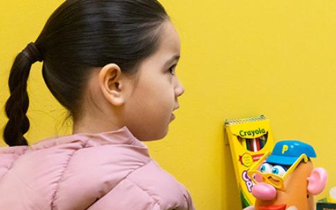 Young girl playing with Mr. Potato Head