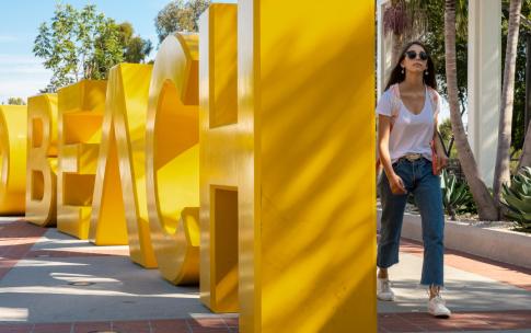 student walking by GO BEACH letters