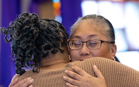 Two women hugging at Super Sunday