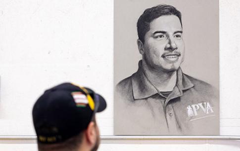 Veteran Jose Reynoso looks at his portrait