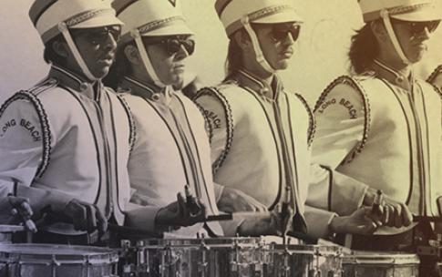 Four drummers in marching band uniforms