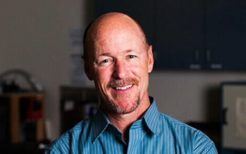 Portrait of Chris Lowe, Shark Lab director at CSLUB, in a blue shirt with his arms crossed