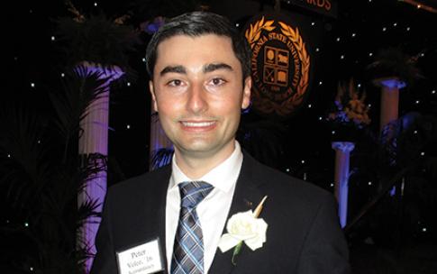 CSULB alumnus Peter Velez '16 holding an award
