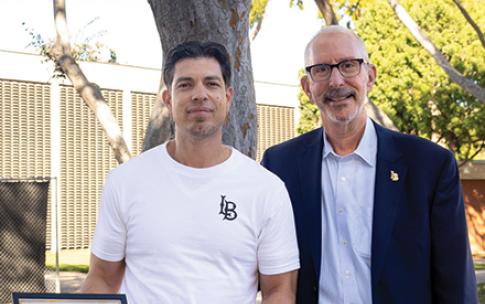 Employee of the Month stands with campus president