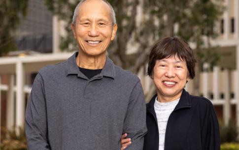 Two people stand in front of building