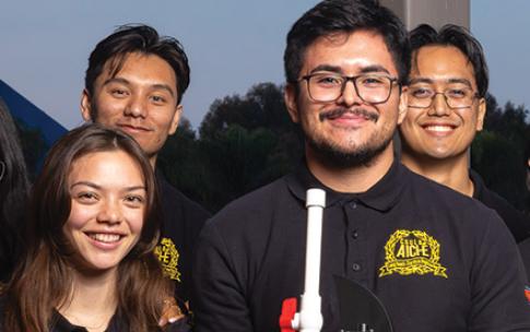 Students pose with model car