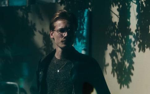 A CSULB student researcher reflected in a shark tank's glass