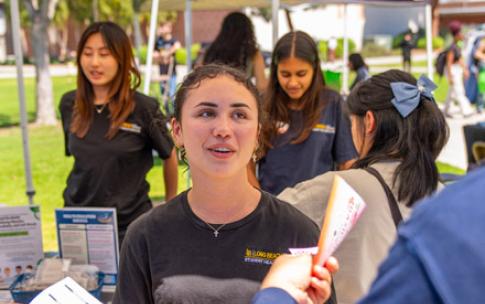 A student hands out information on financial literacy