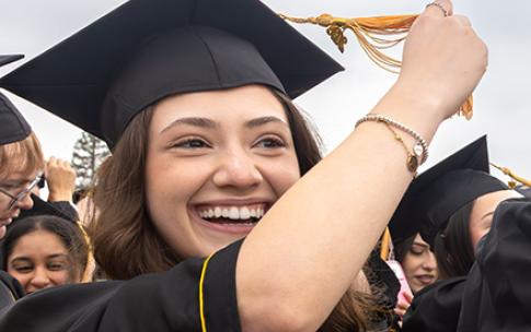 A graduate in regalia turning her tassle