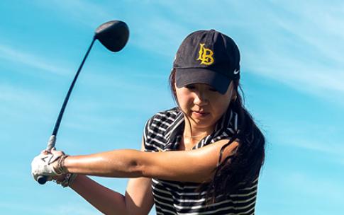 Golfer swings a club outdoors