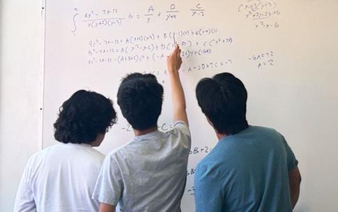 Math students work on a problem on the whiteboard