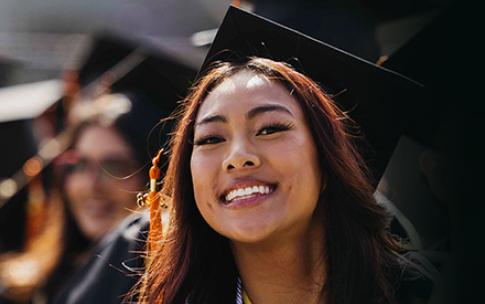 A young woman smiles at Commencement