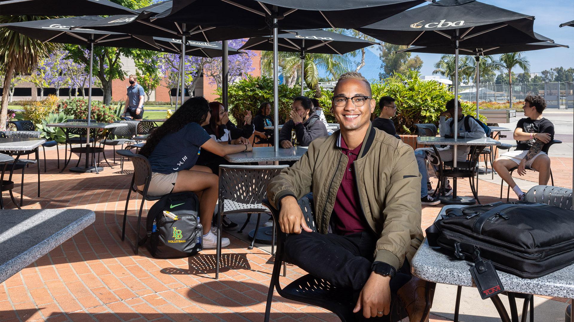 Austin Metoyer sitting outside College of Business building
