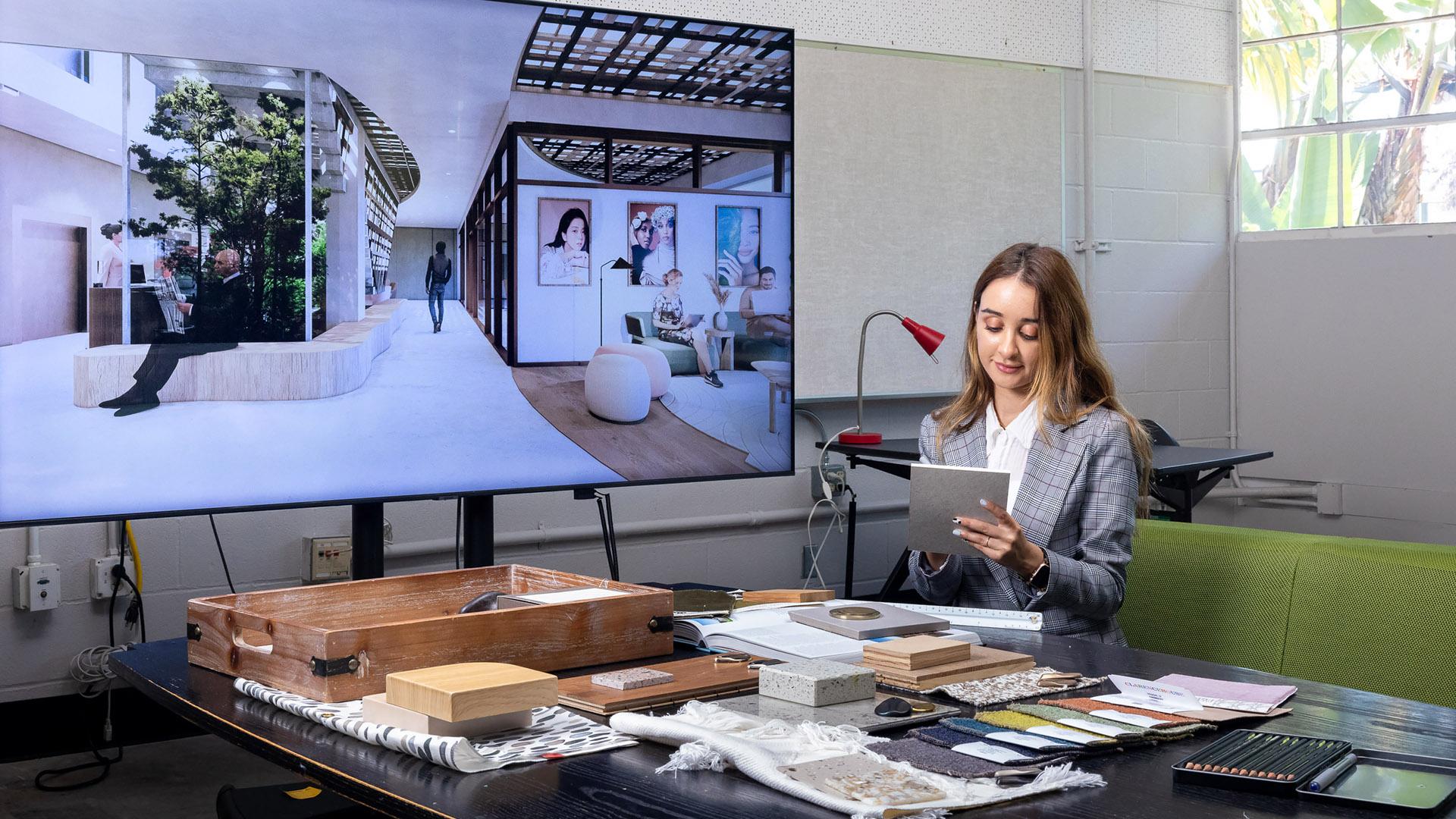 Nevi Gruskin checks her design work near giant video screen