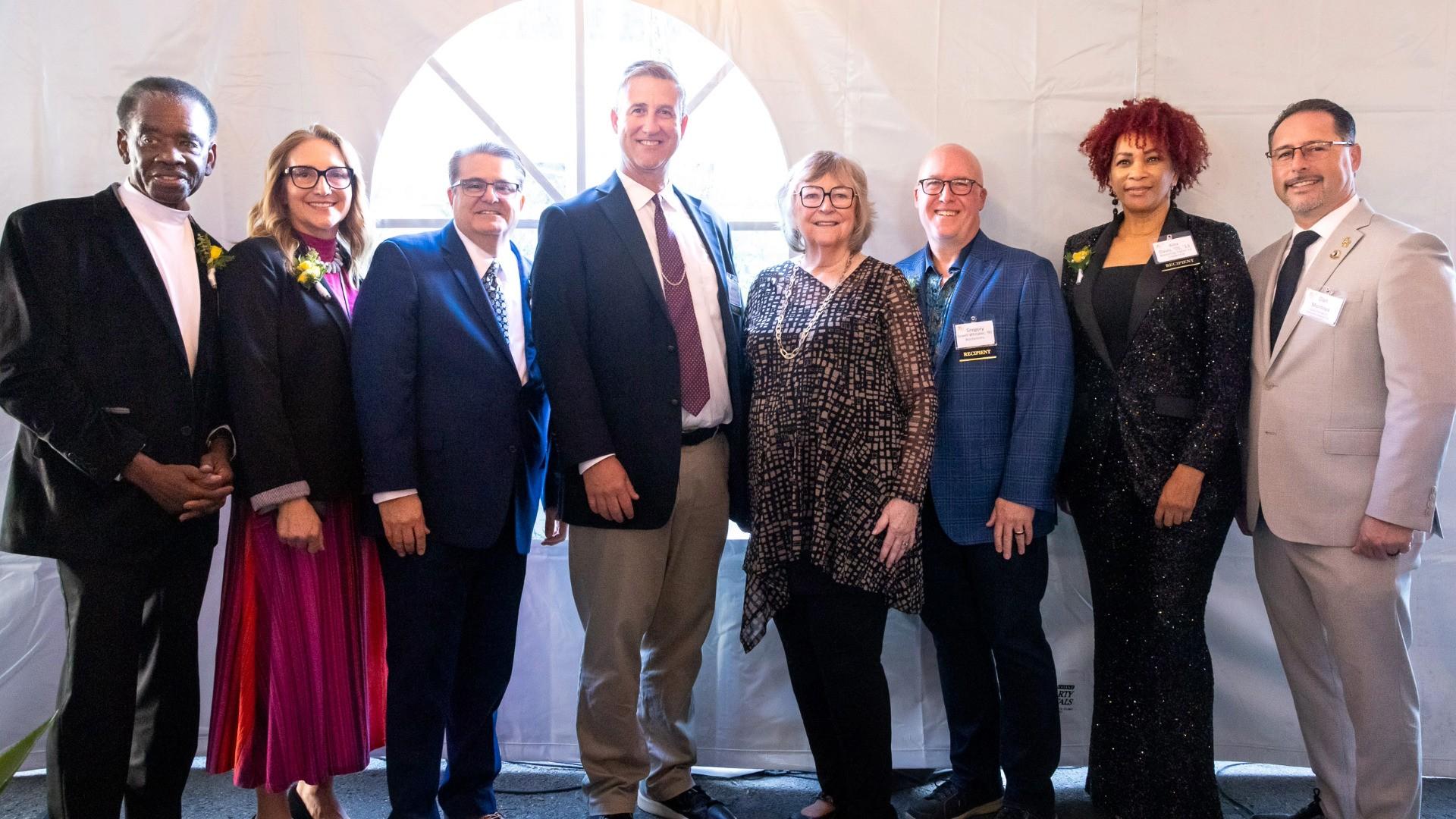 2025 Distinguished Alumni honorees standing shoulder-to-shoulder with President Jane Close Conoley and Vice President Dan Montoya