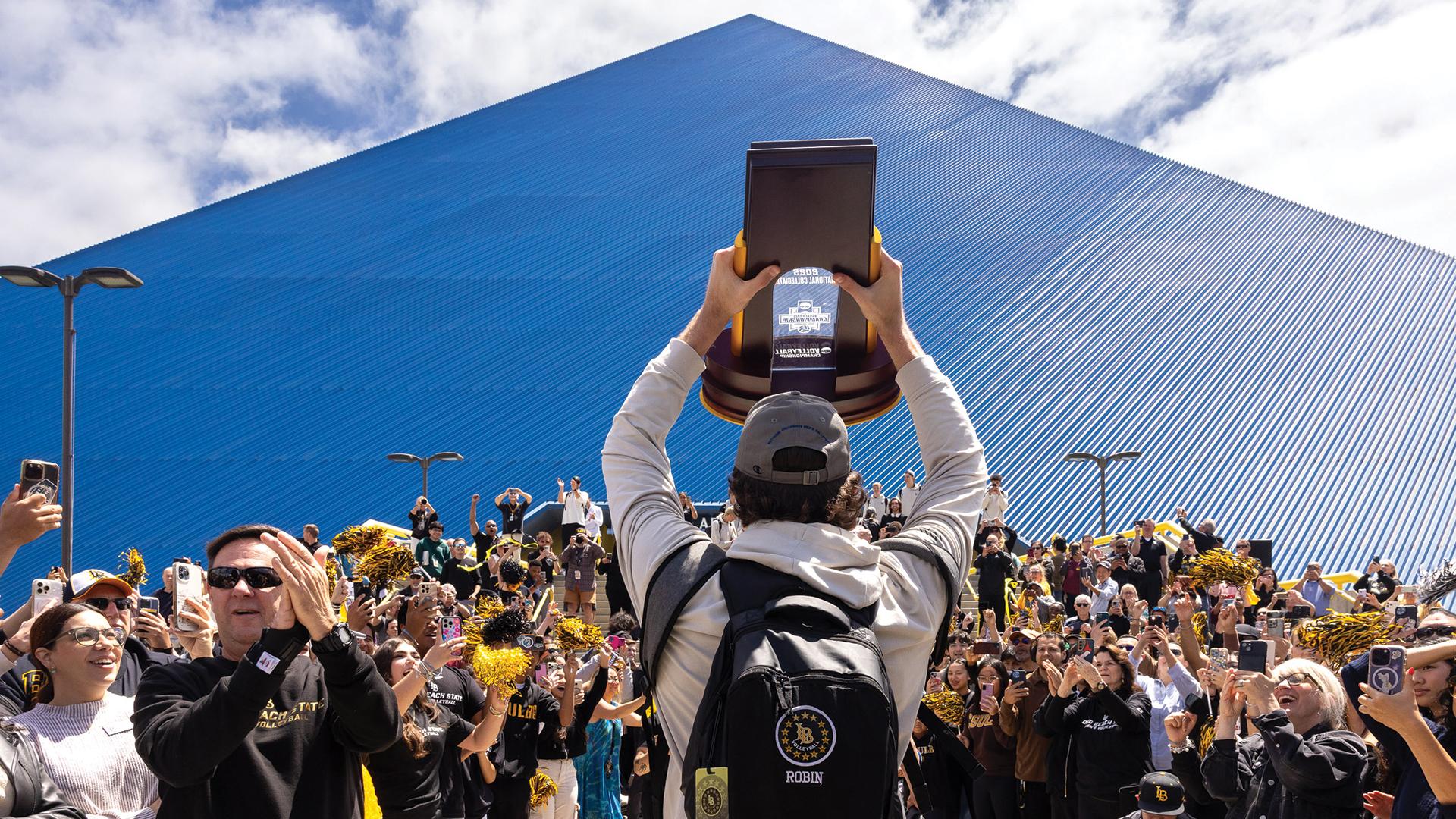 A Men's Volleyball player with National Championship trophy