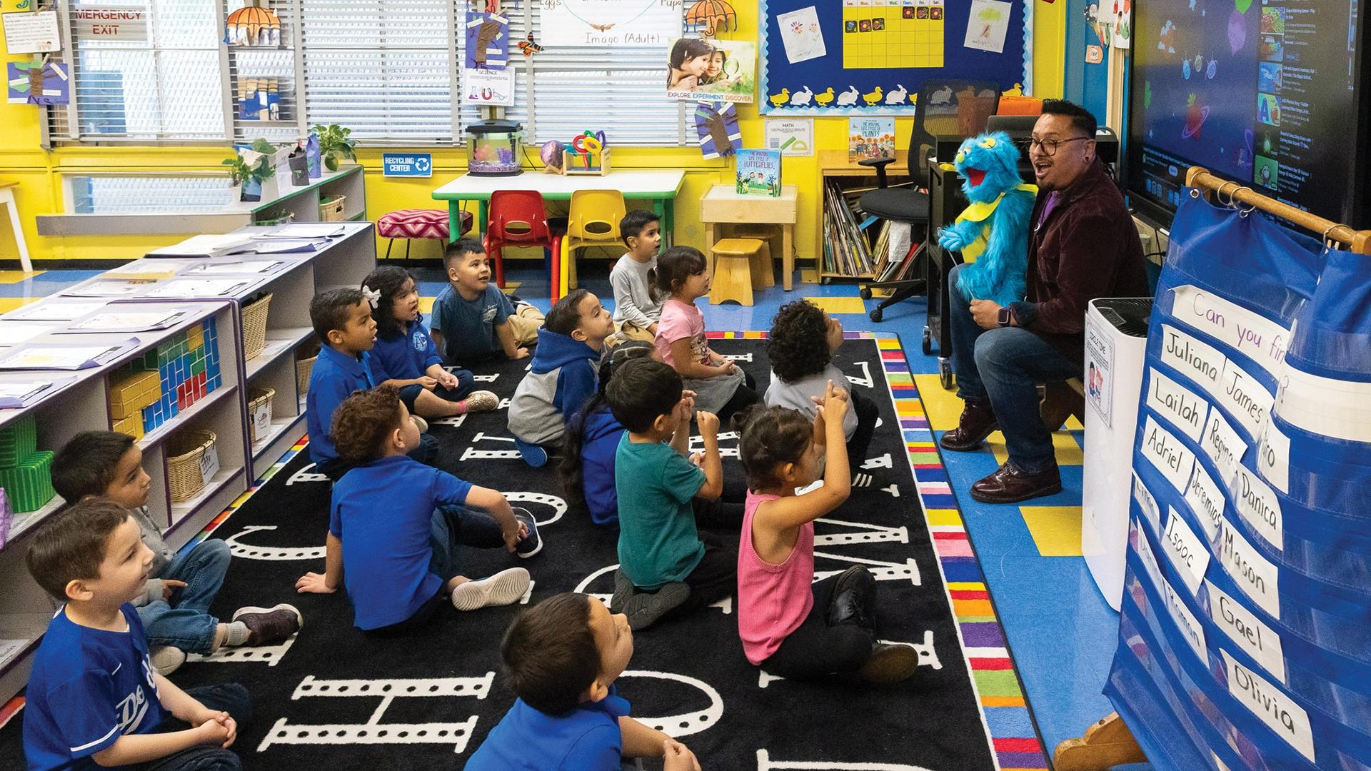A teacher, also a CSULB student, using a puppet to teach children