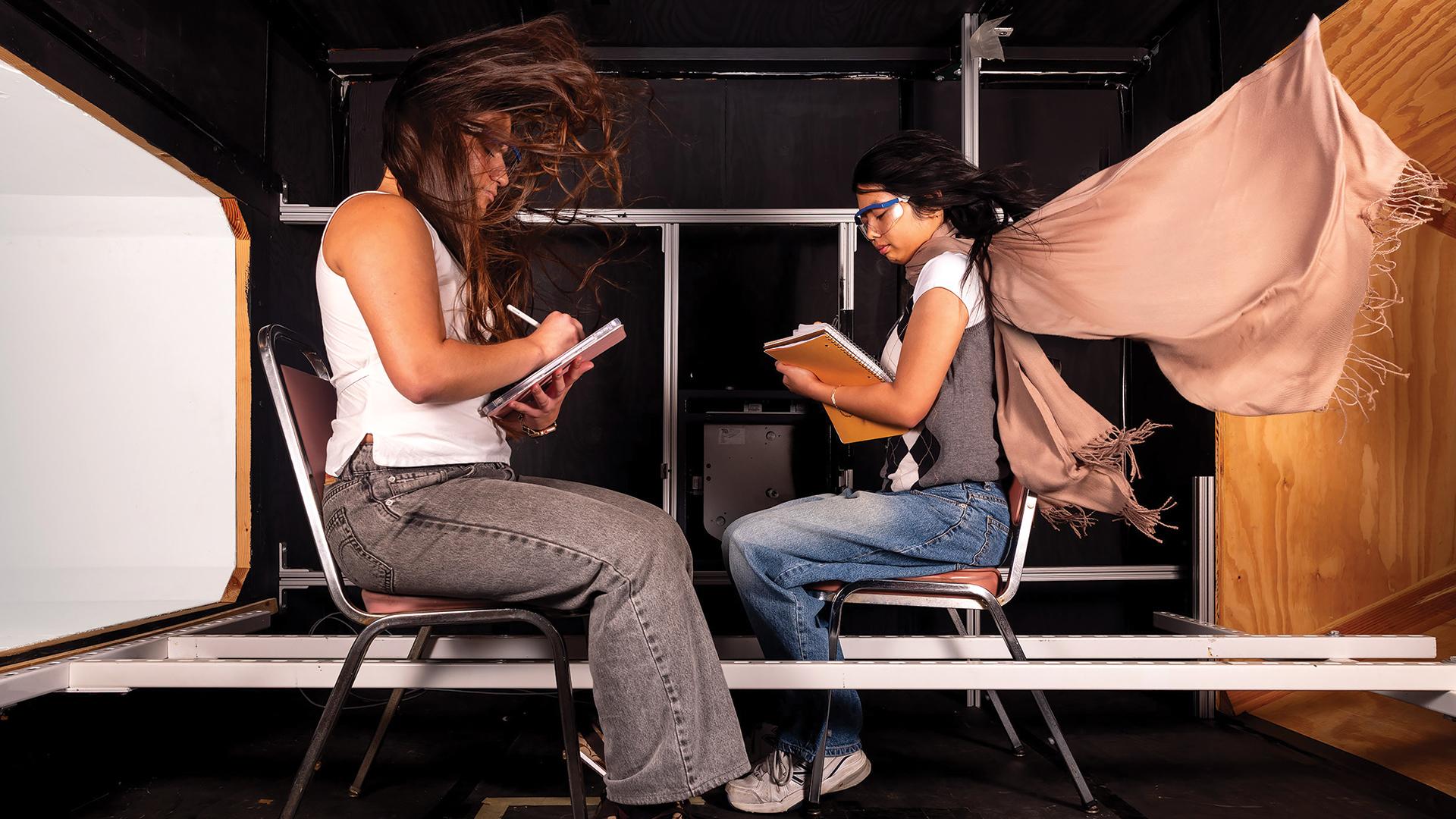 Two people take notes in a wind tunnel