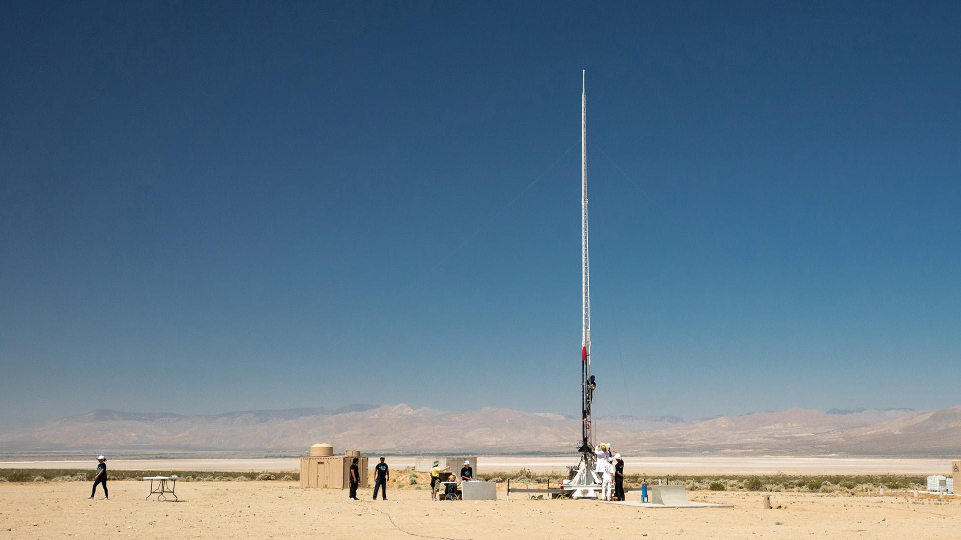 People in the desert prepare to launch a rocket