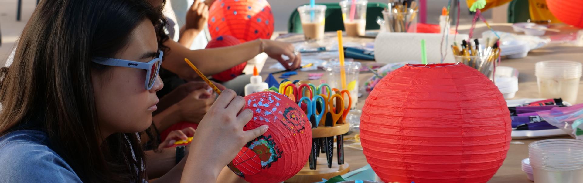 Student painting paper lanterns
