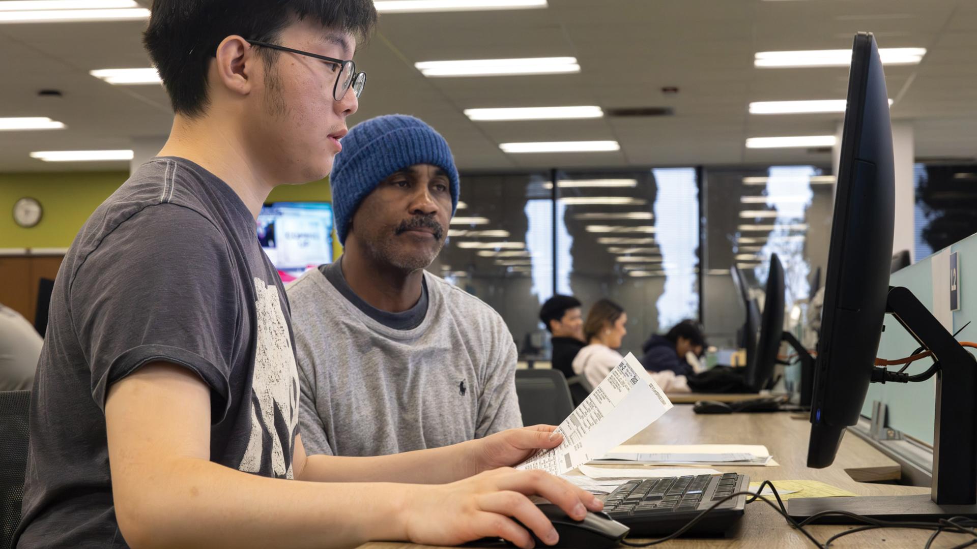 CSULB accounting student Christopher Park helping a client with taxes