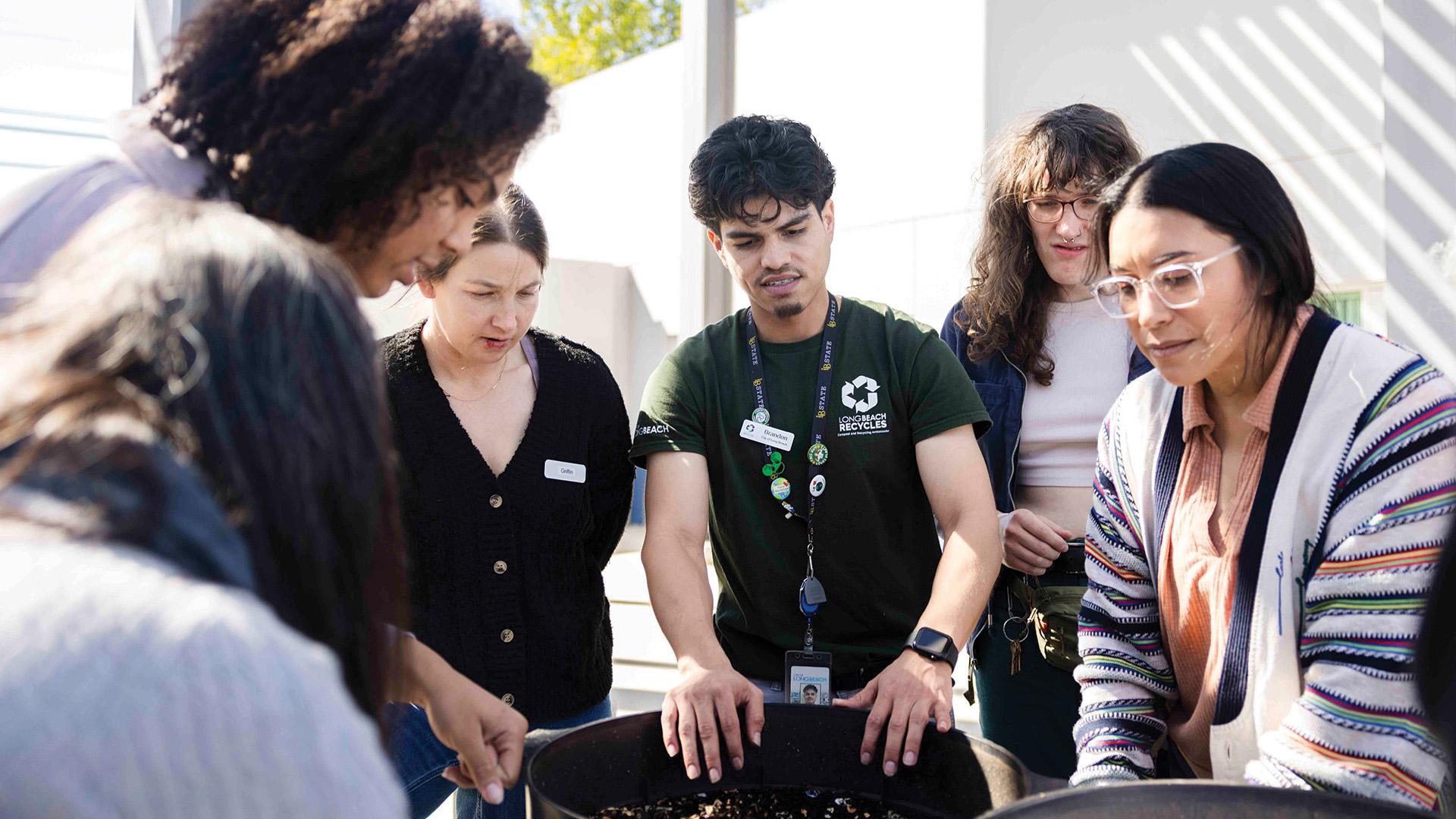 College Corps @ The Beach alumnus Brandon Contreras '23 (center) leading a composting class