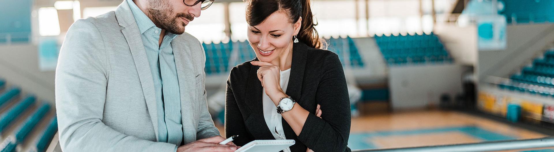 Two people talking business at a sporting arena