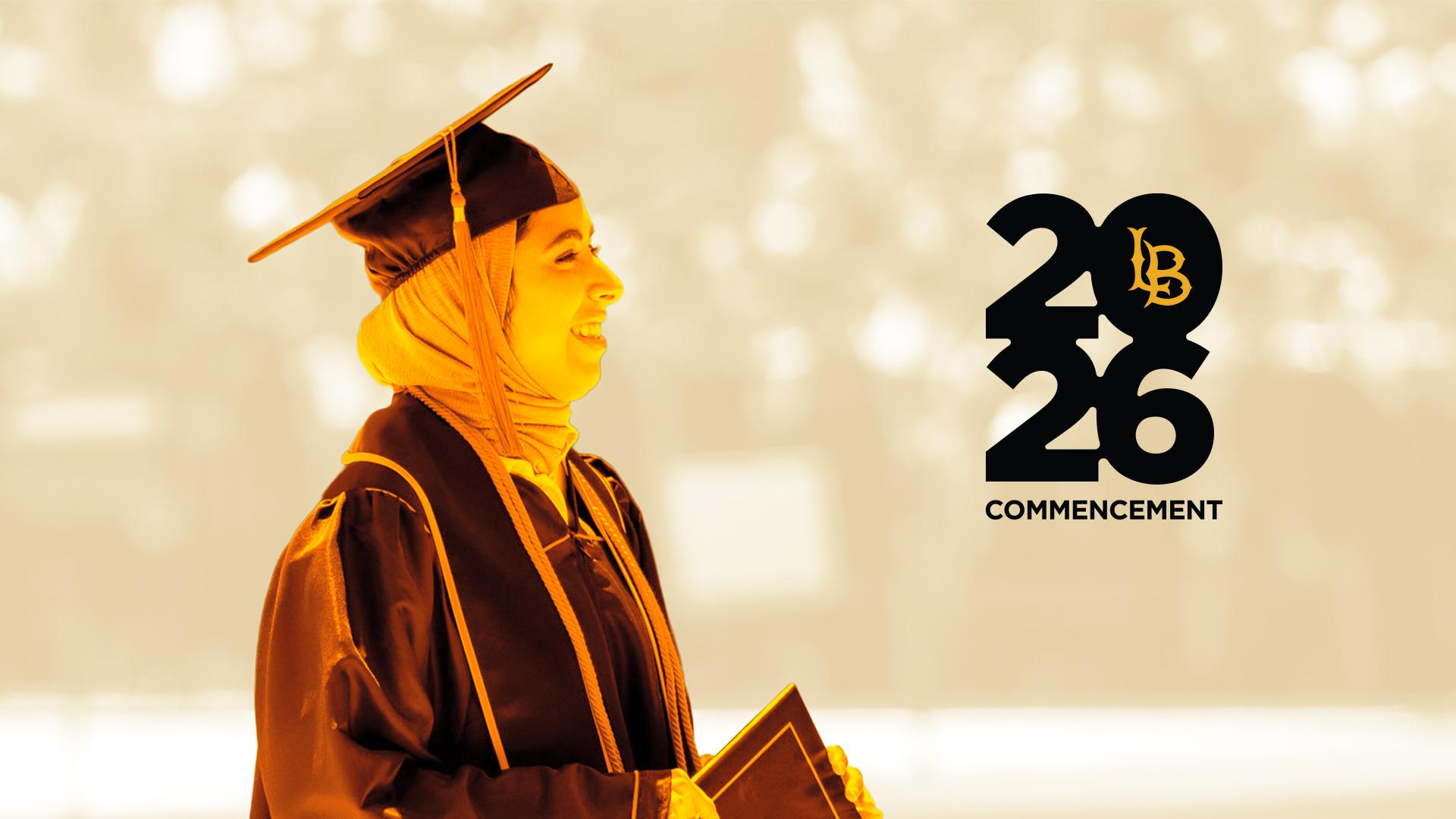 A recent graduate smiling in full regalia