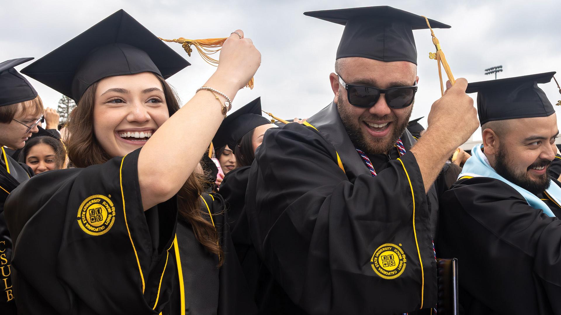 CSULB graduates moving tassels on their caps from right to left