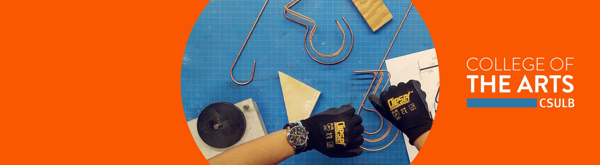 College of the Arts - astudent works on a design with hooks and wire