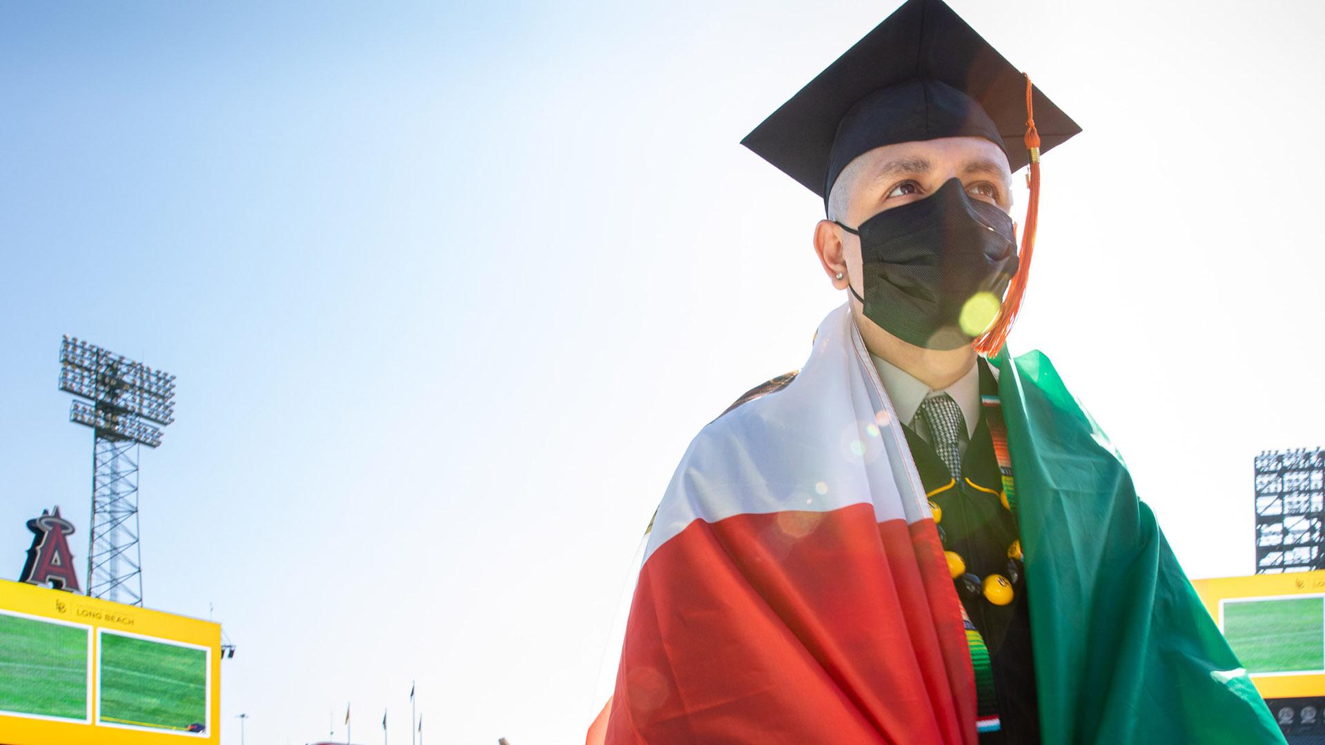 Graduate with Mexican flag wrapped around his shoulders