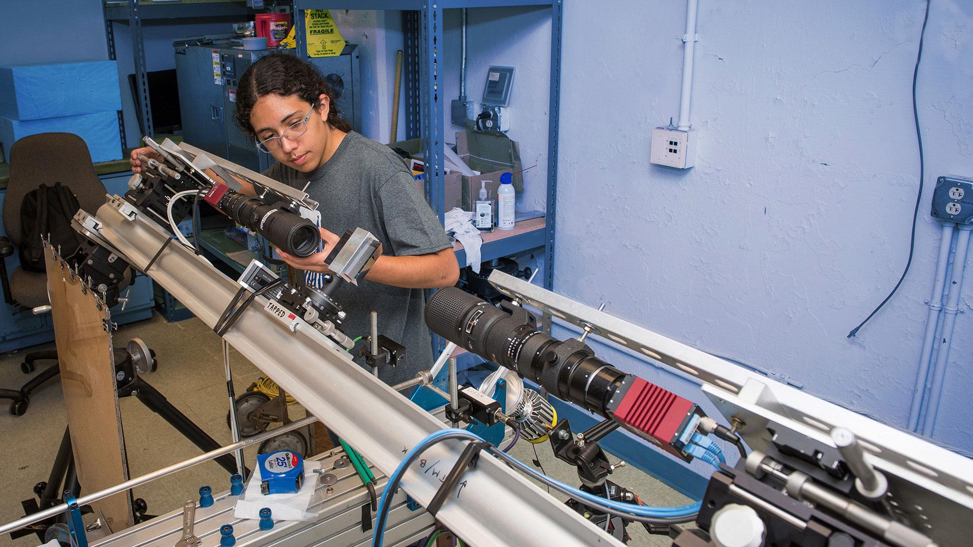 Joaquin Martinez inspects an instrument at NASA