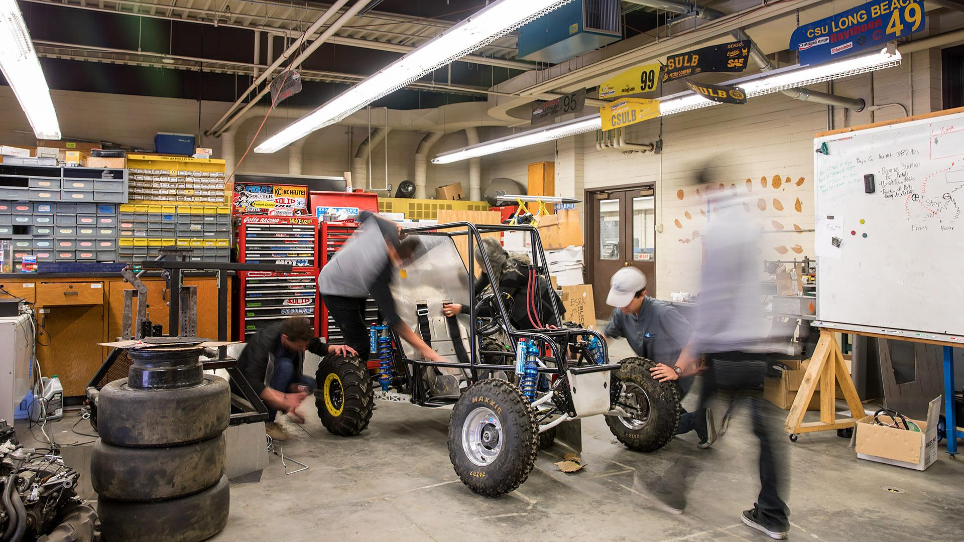 Engineering students work on baja car.