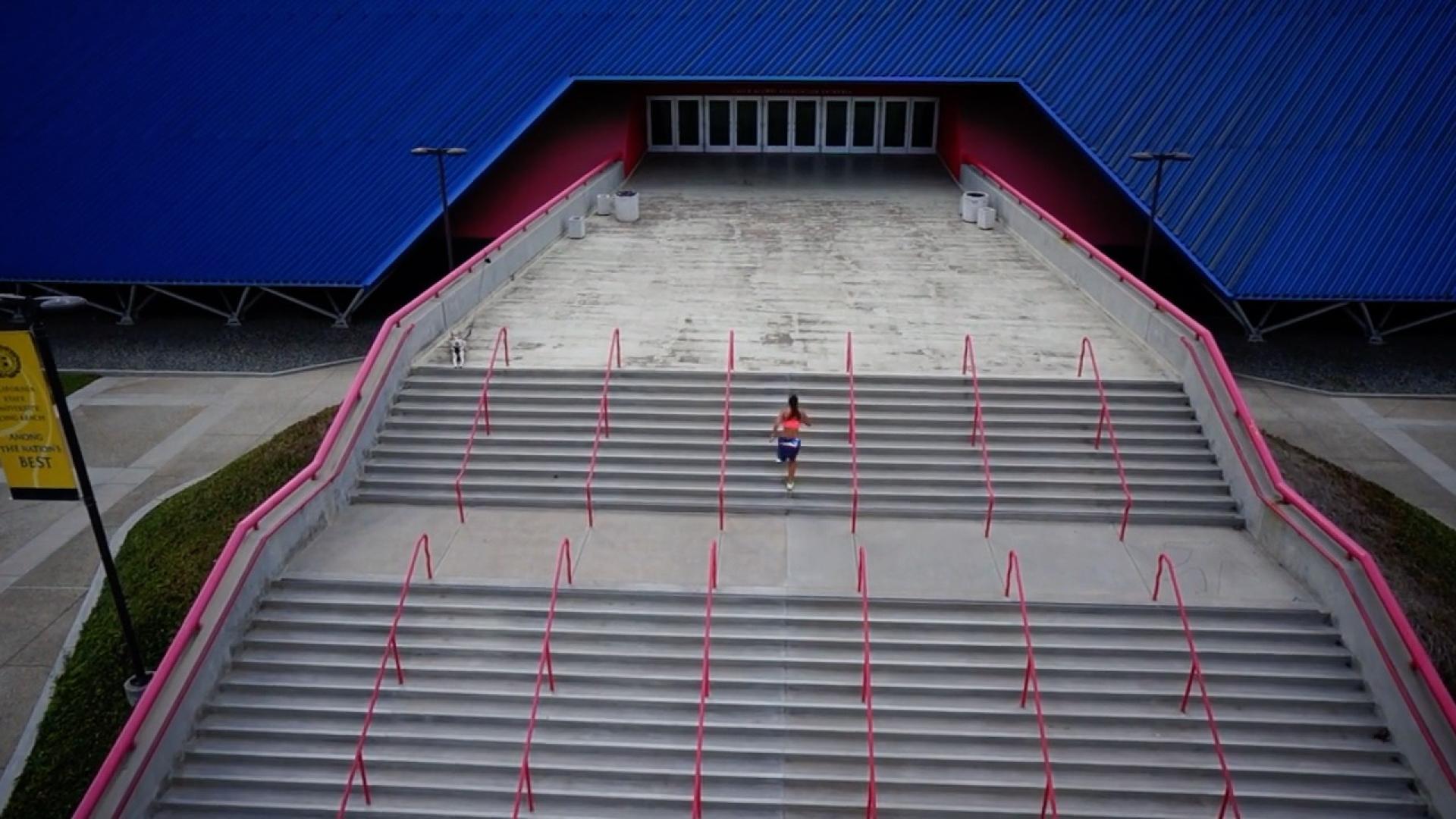 Woman runs up steps of the Pyramid.