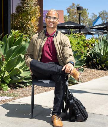 Austin Metoyer sitting outside College of Business building