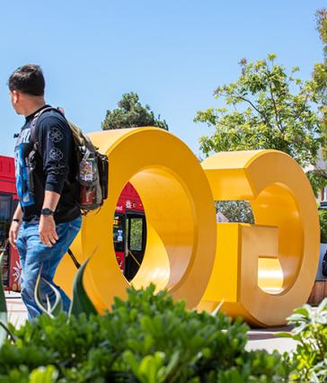 Students walk by the GO BEACH letters