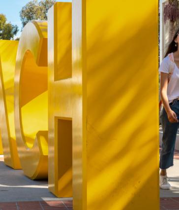 student walking by GO BEACH letters