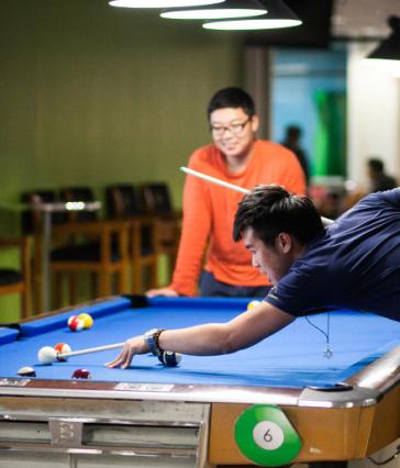 Students playing pool at the Games Center