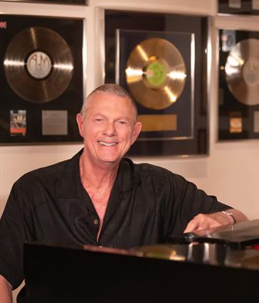 Richard Carpenter at piano, gold records behind him