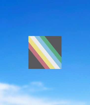 Disability Pride Flag against a blue sky. Please read caption.
