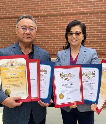 Kensaku Nakayama and Lijuan Li holding multiple award certificates