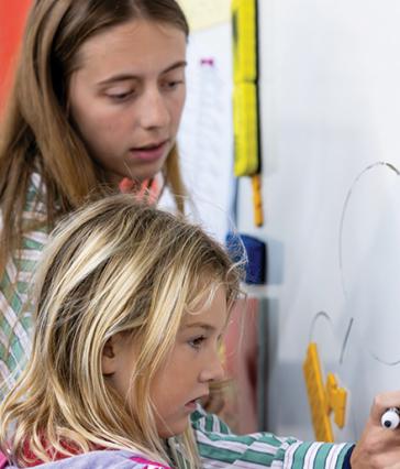 Student teacher Tess Walker instructs an elementary school student
