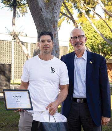 Employee of the Month stands with campus president