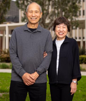 Two people stand in front of building