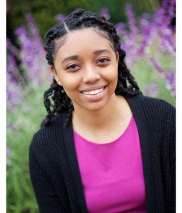 Asia Woods - girl smiling in front of purple flowers