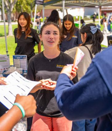 A student hands out information on financial literacy