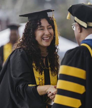 Graduate is greeted by faculty at commencement
