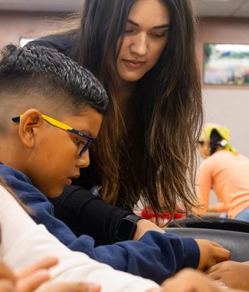 CSULB student teacher Fernanda Naranjo helps a student from Handy Elementary